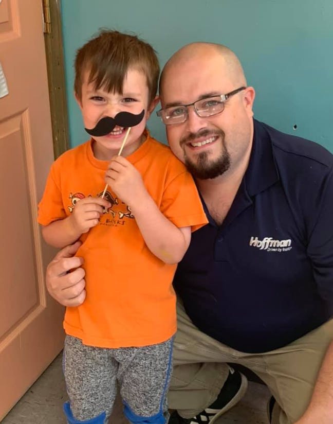 Adult and child posing with a fake mustache prop