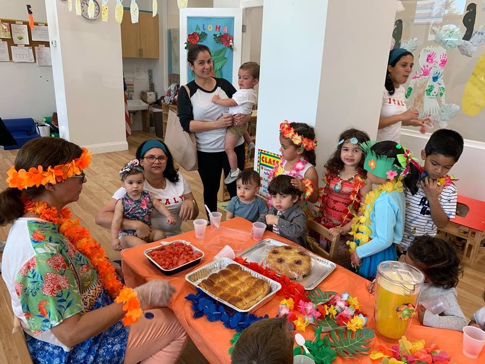 Adults and children gathered around a table with food
