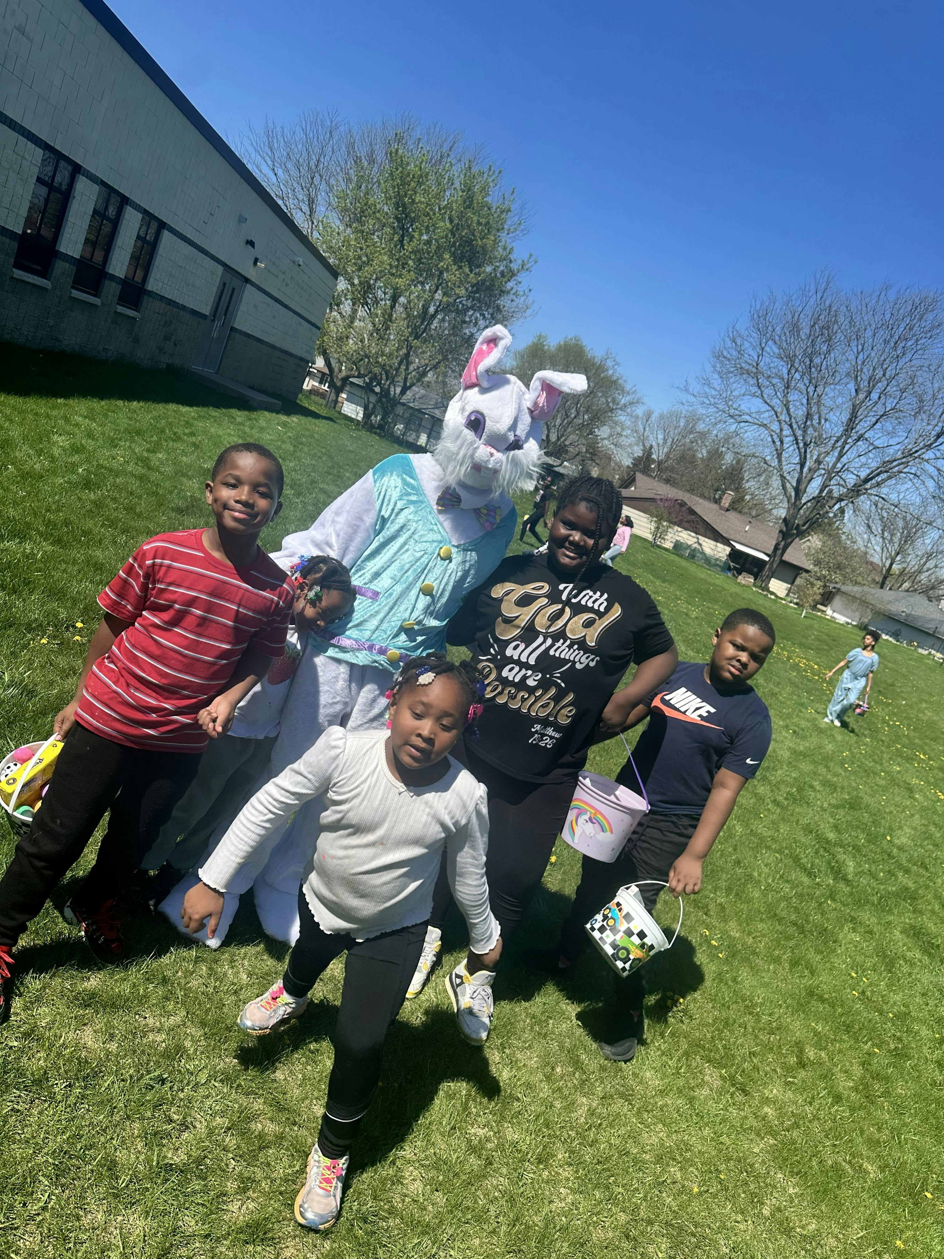 Group of children standing with a person in an Easter bunny costume outdoors