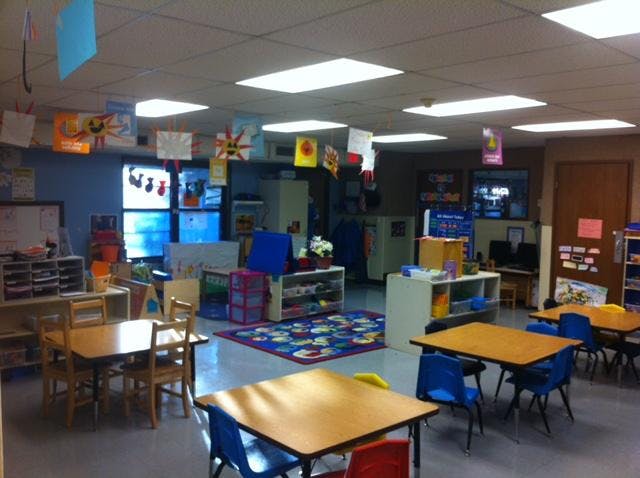 An empty classroom with small tables and chairs