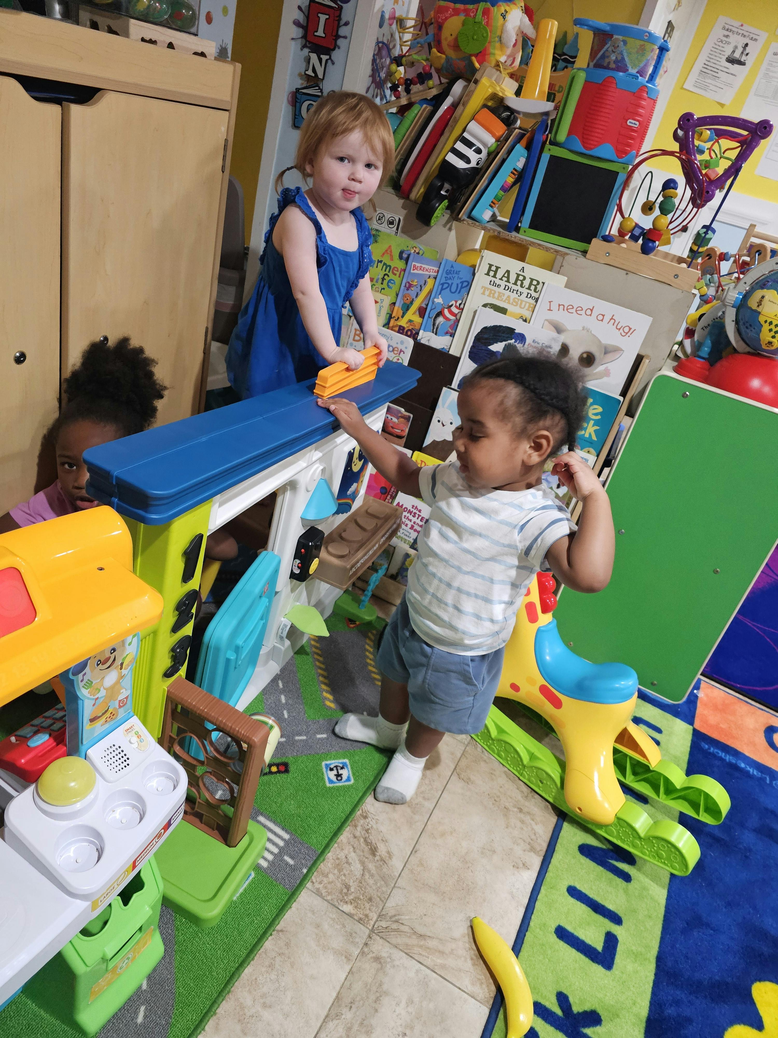 two children playing with toys in a classroom