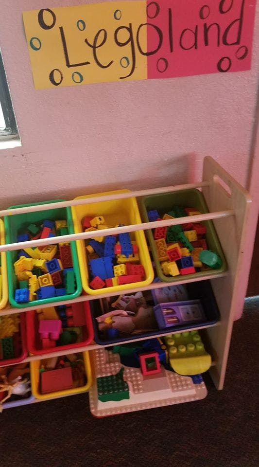 Toy organizer with colorful building blocks and a "Legoland" sign