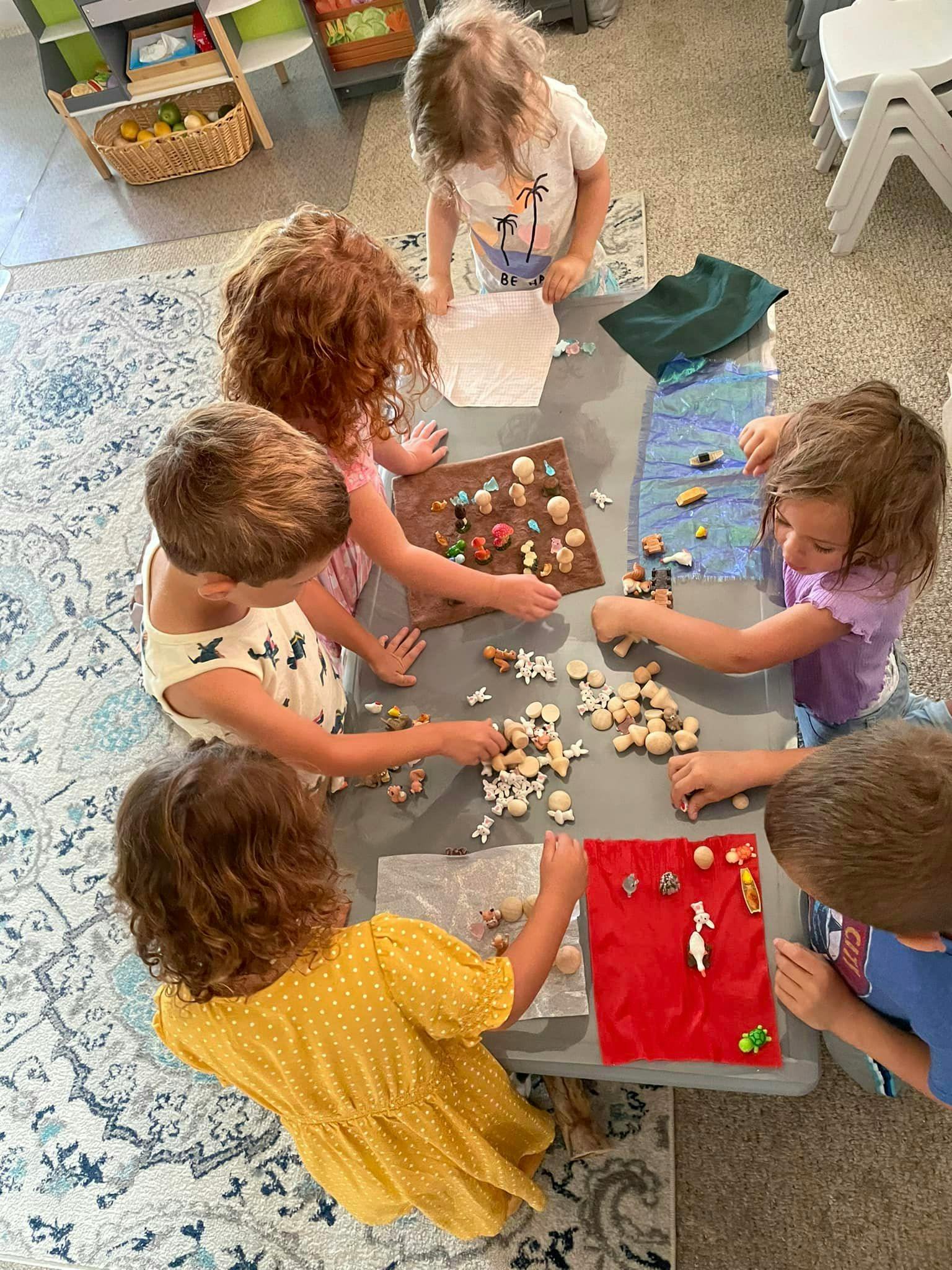 Children playing with small objects at a table