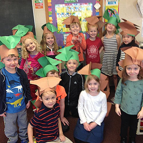 Group of children wearing paper hats, plant-themed hats