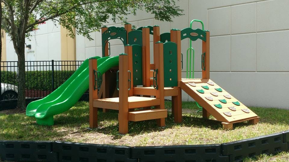 Playground with green slide and climbing wall
