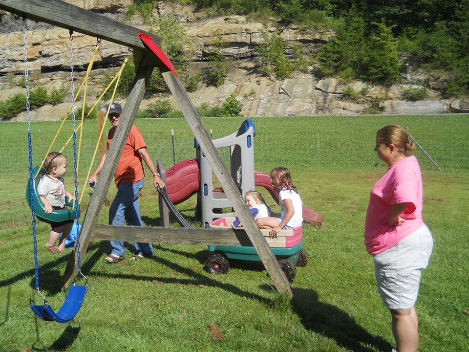 People and children on a swing set and playground