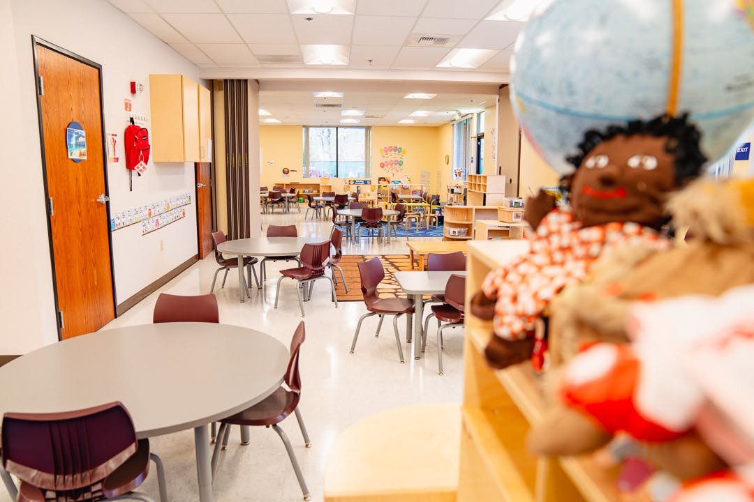 Classroom with tables and chairs, toys in foreground