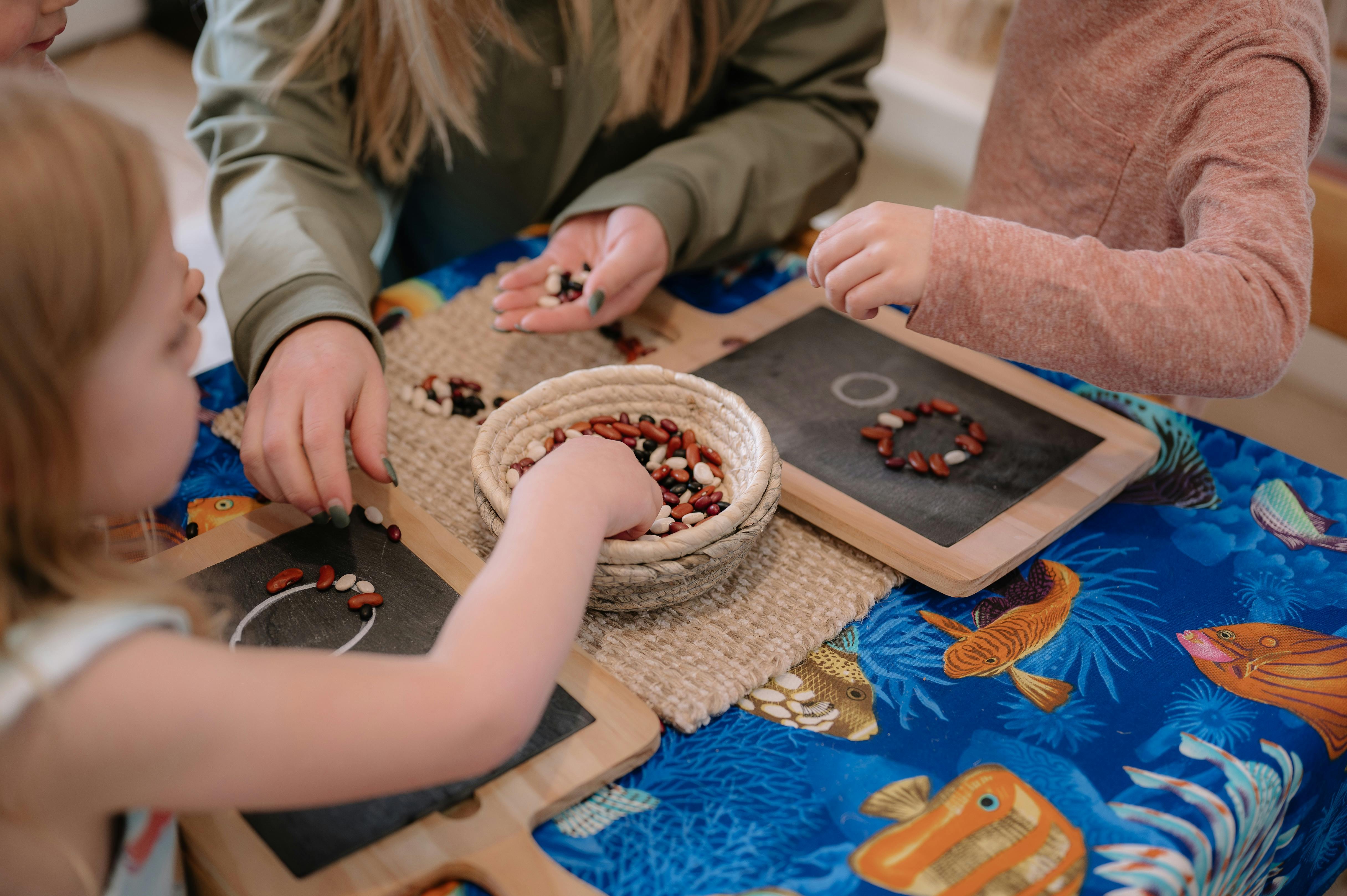 People and a child making patterns with small objects on a table