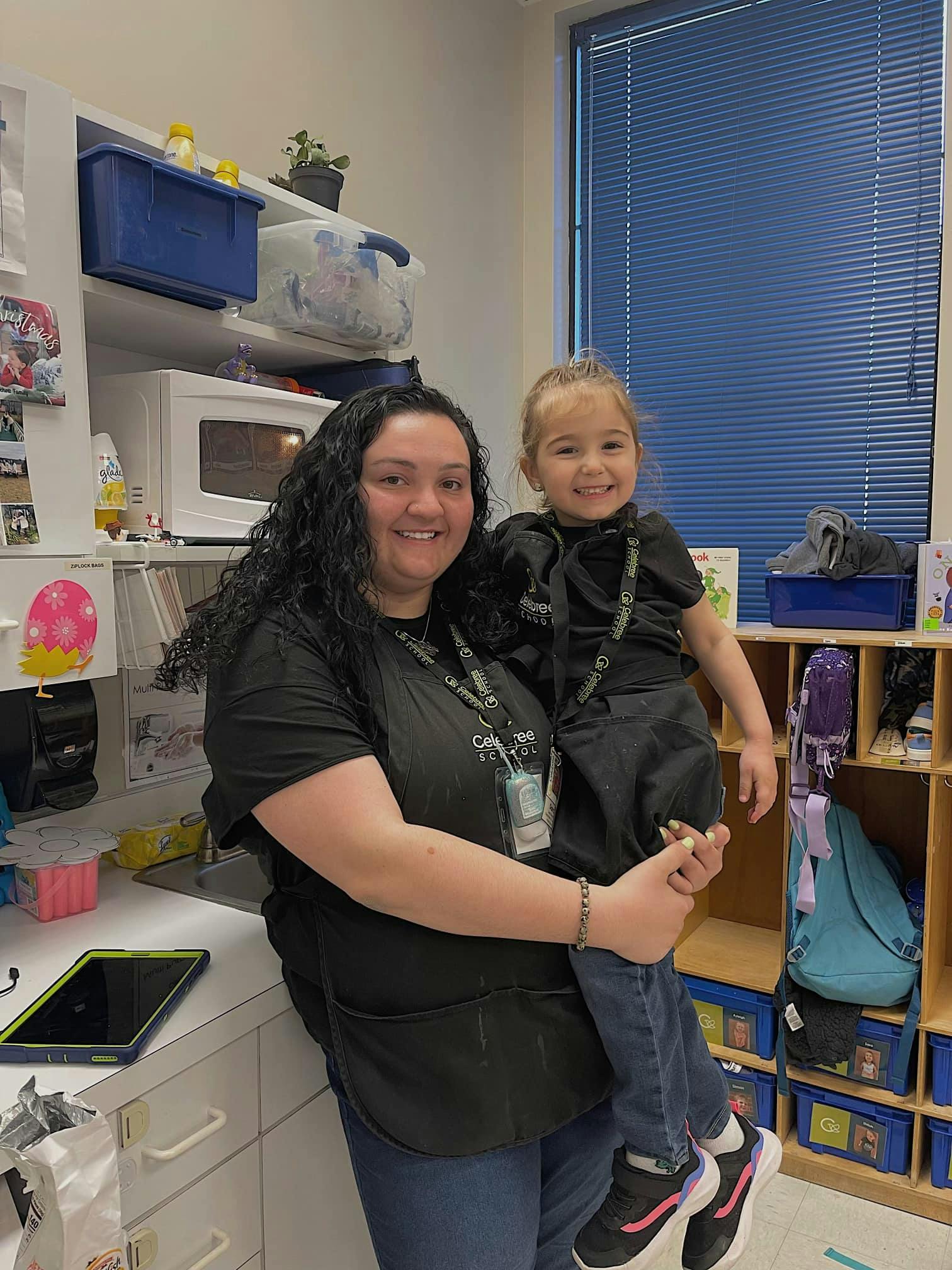 Person holding a child in a classroom