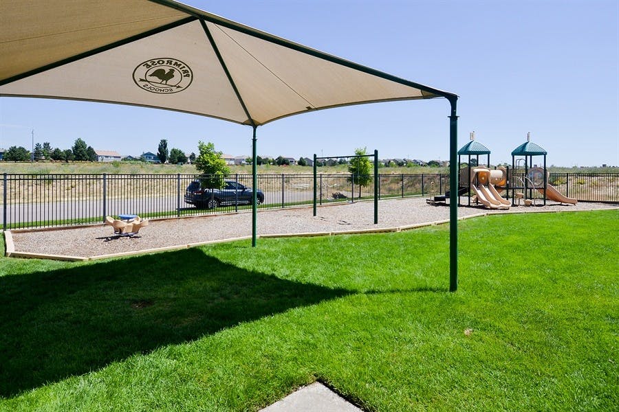 Playground with slides and swings under a shade structure