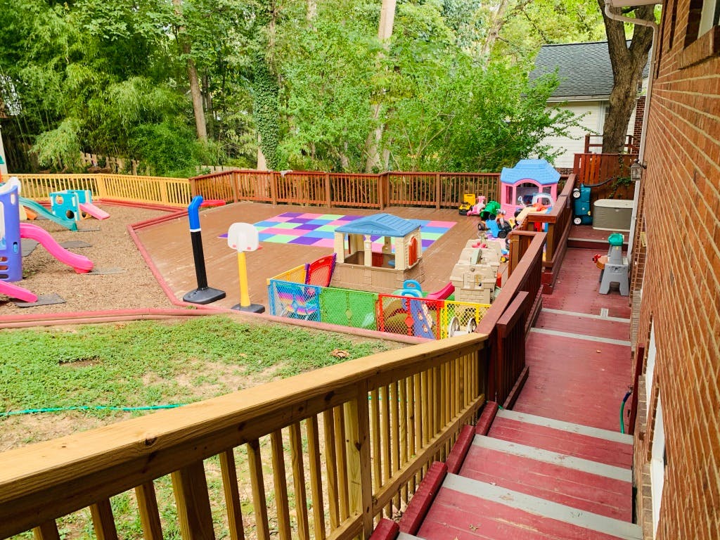 Outdoor playground with slides, playhouses, and colorful mats