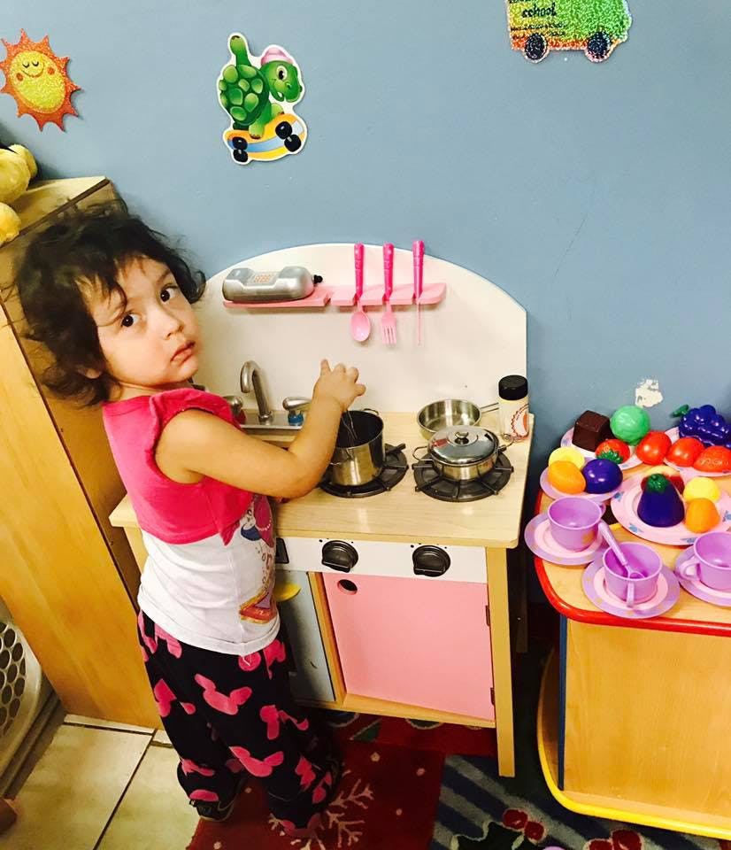 Child playing with a toy kitchen set