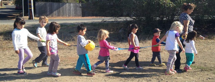 Children walking in a line with an adult