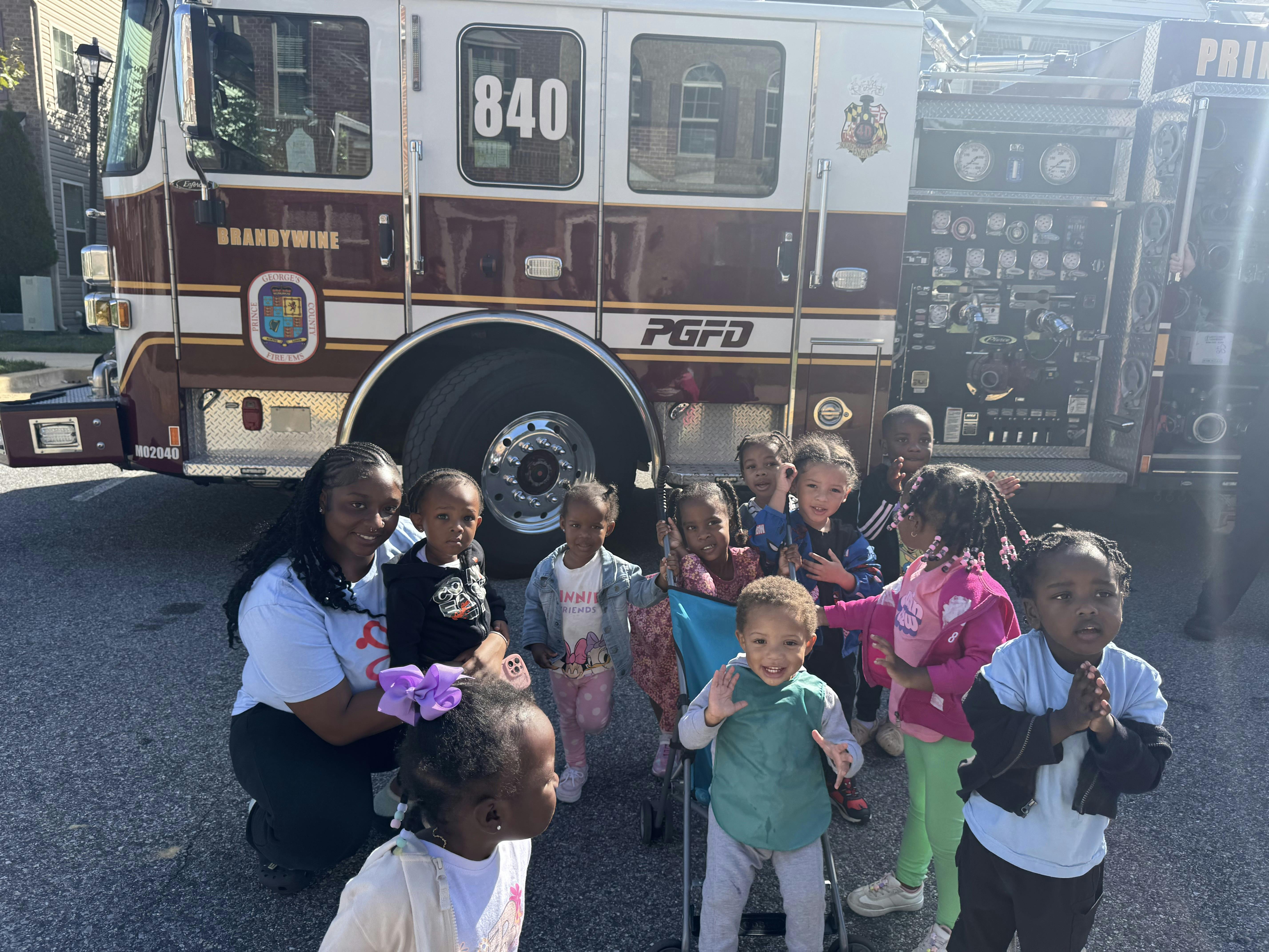 Person and children in front of a fire truck