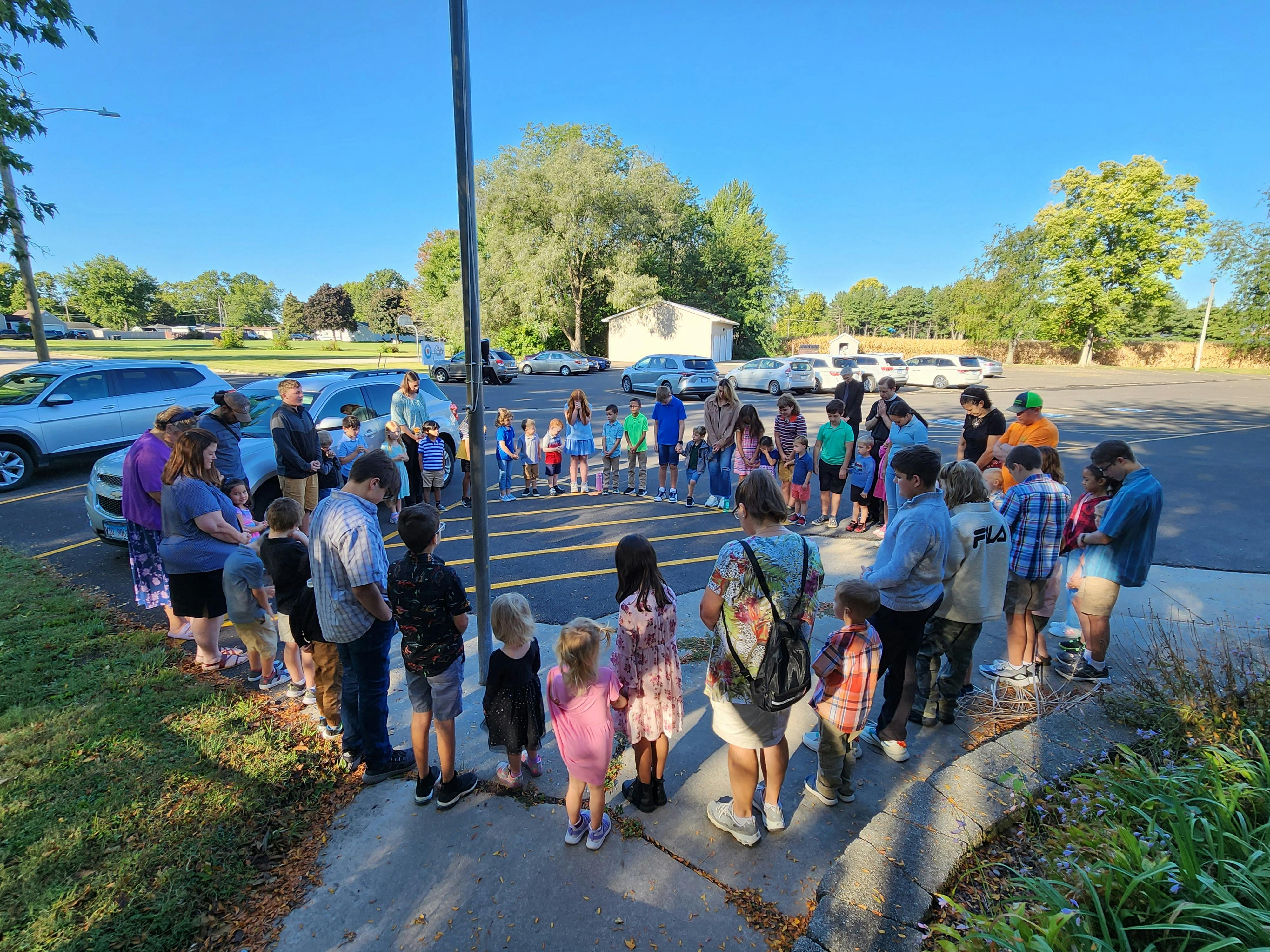 Group of people and children standing in a circle outdoors
