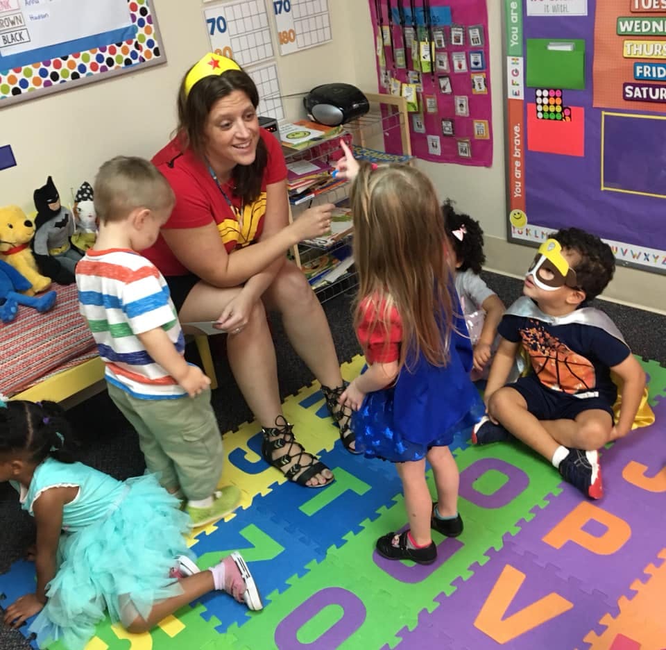 Person in a classroom interacting with children