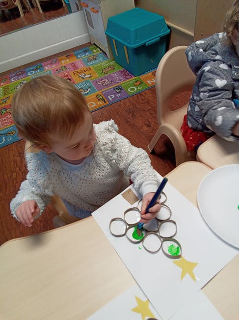 Child painting a craft made from cardboard tubes