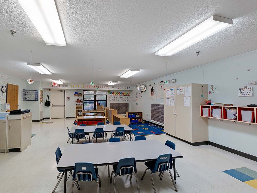 Empty classroom with small tables and chairs