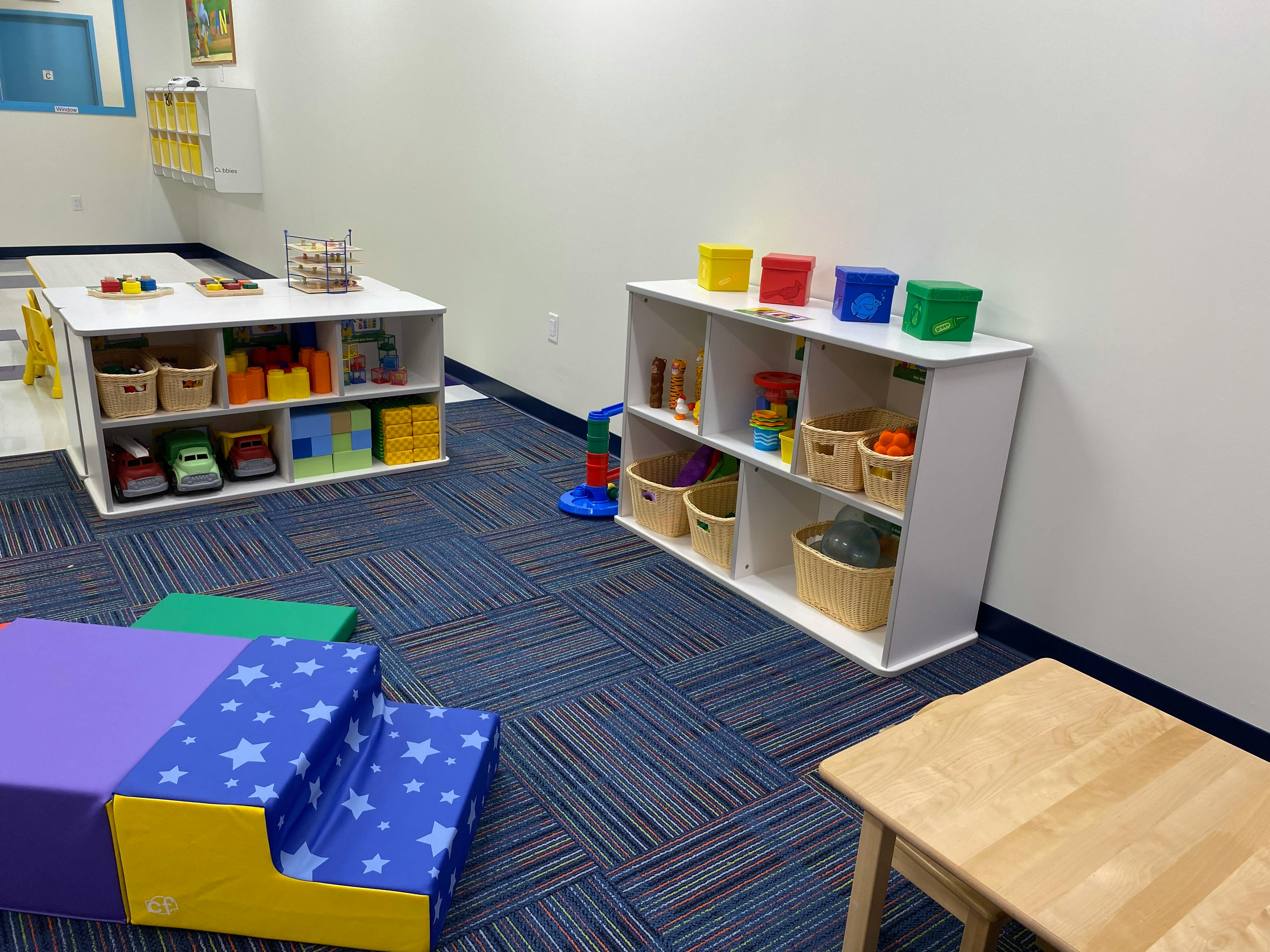 Playroom with shelves of toys and soft play equipment