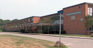 Brick school building with a covered walkway entrance