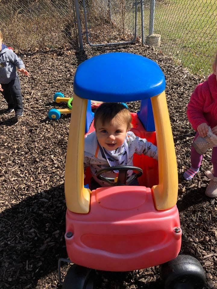 Child in a toy car outdoors