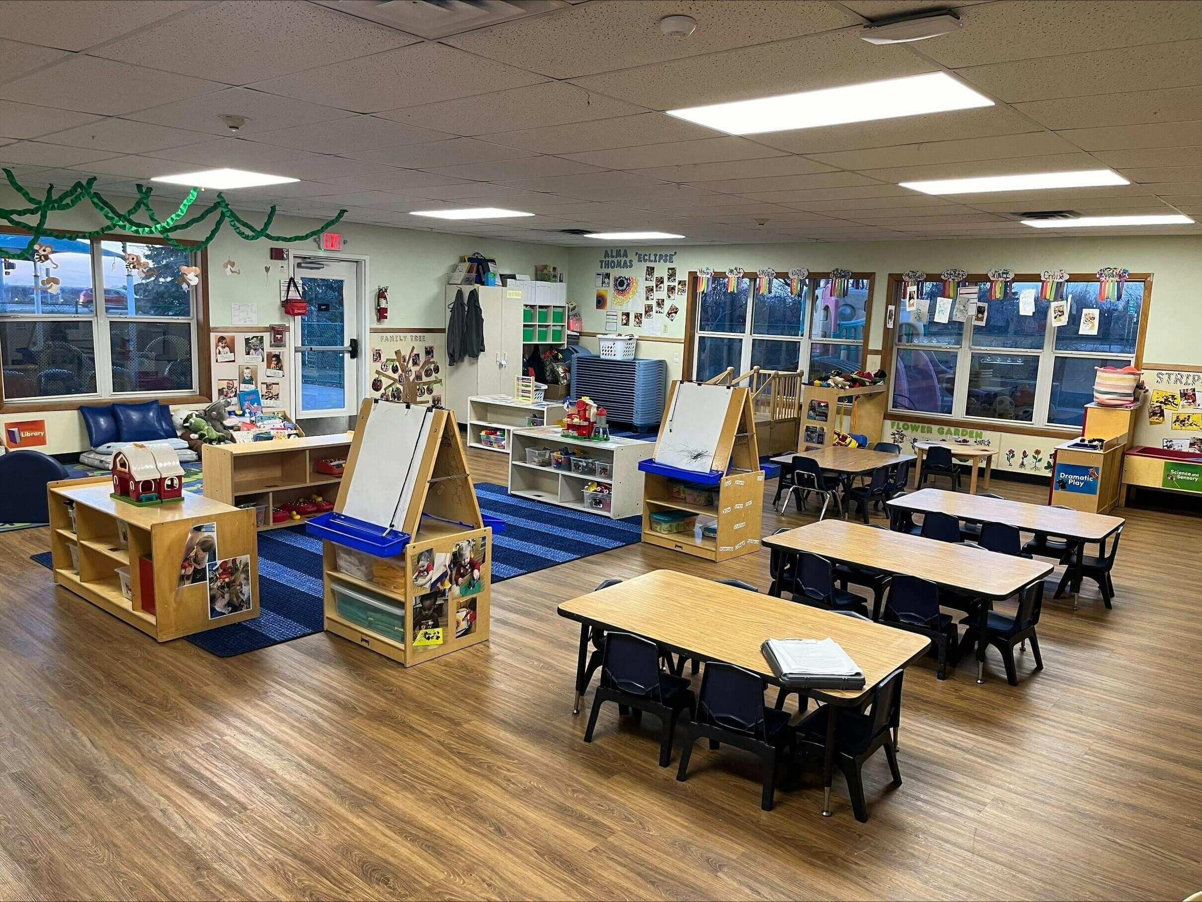 Classroom with tables, chairs, easels, and activity stations