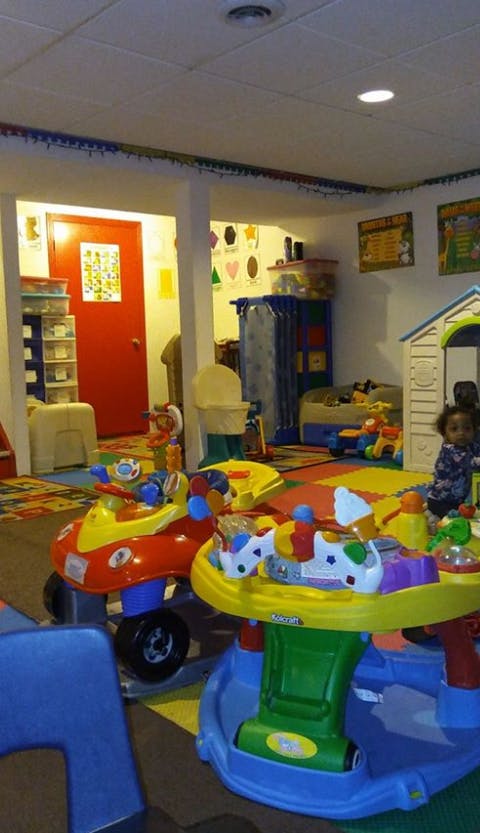 Child in a playroom with various toys and play structures