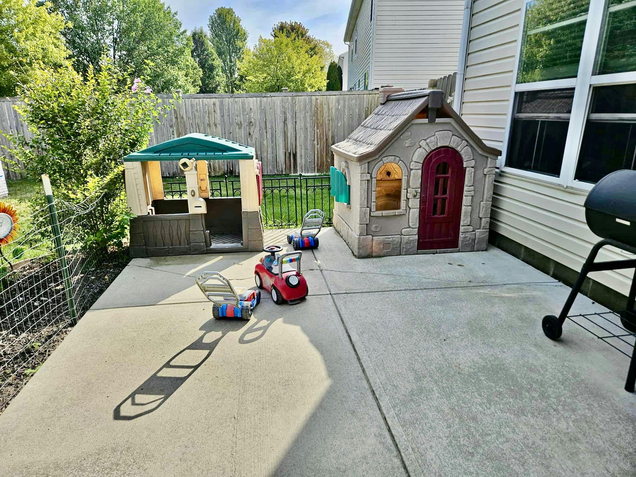 Playhouses and ride-on toys on a patio