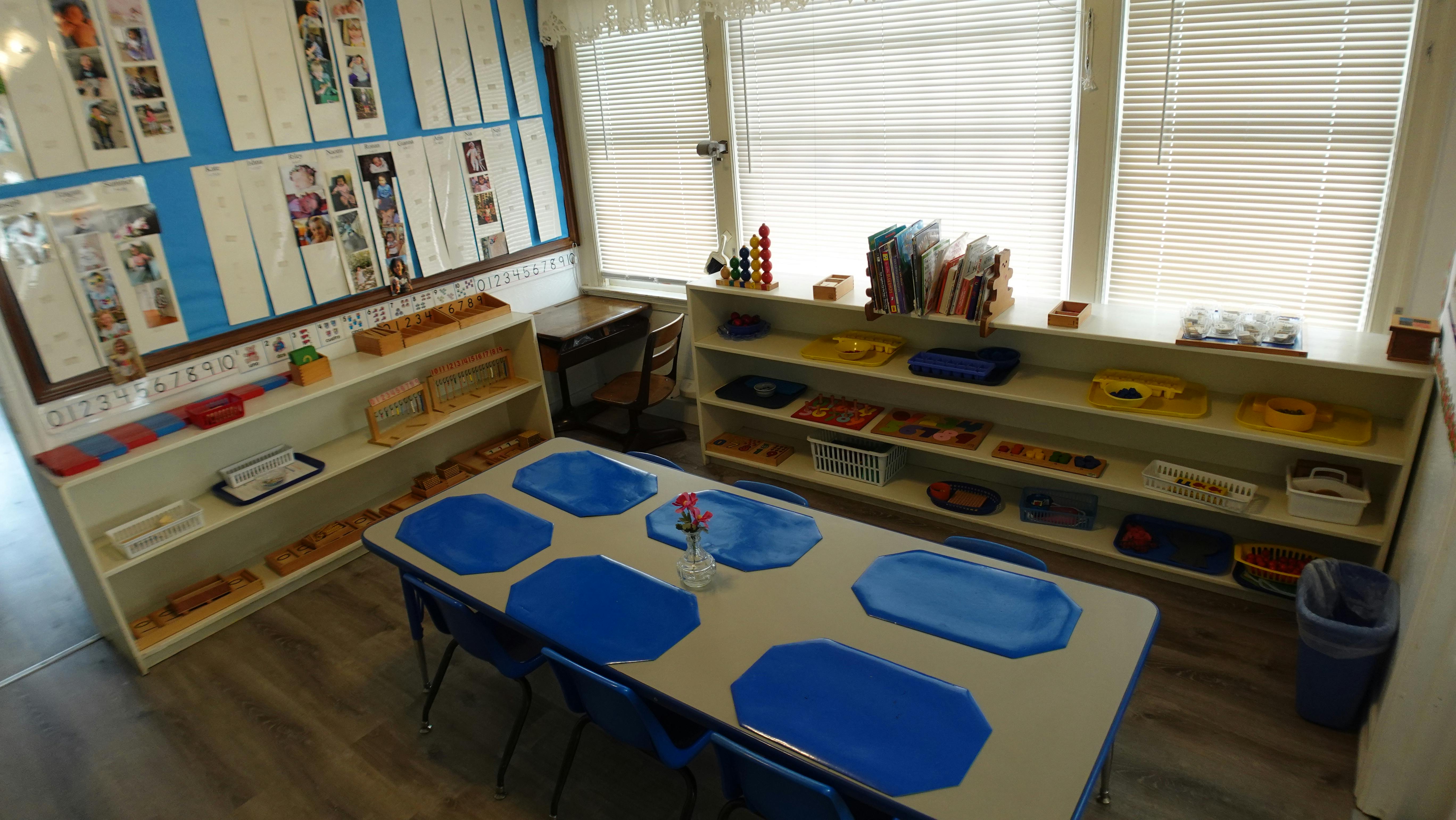 Classroom with tables, chairs, and shelves with learning materials