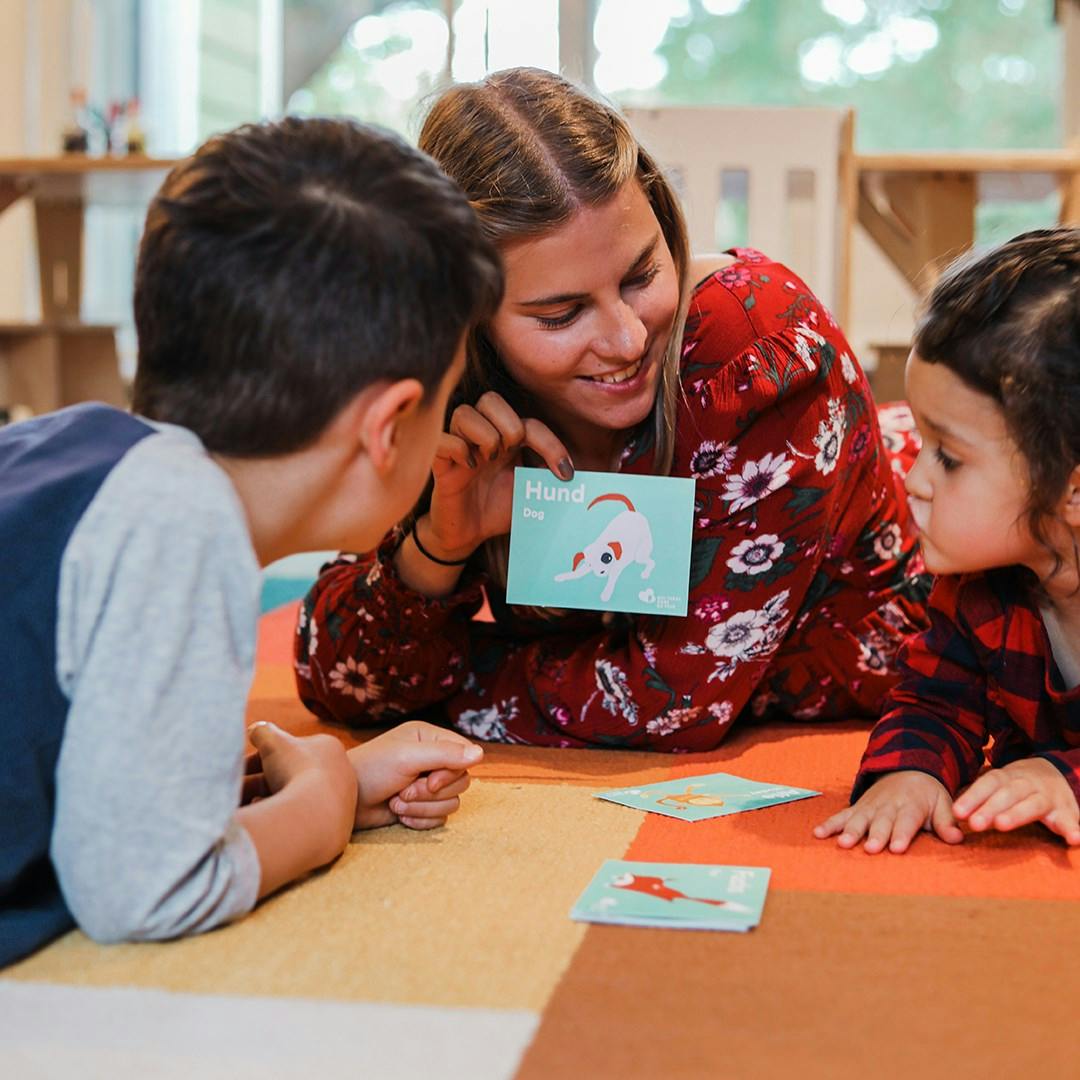 Person showing a card with a drawing to two children