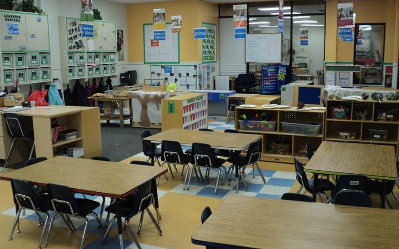 Classroom with small tables and chairs, shelves, and decorations on the walls