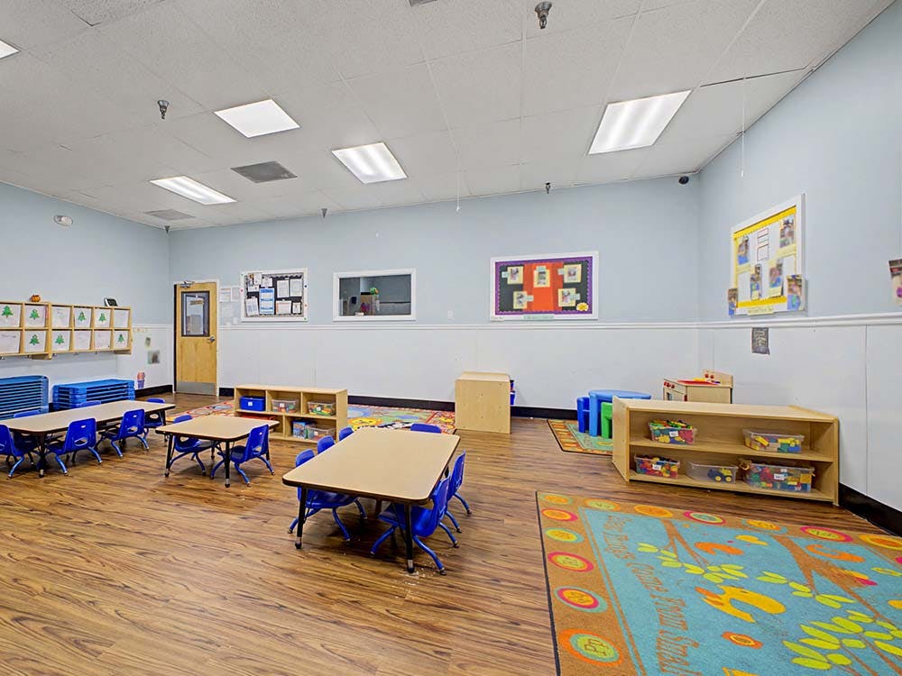 Empty colorful preschool classroom with tables and chairs