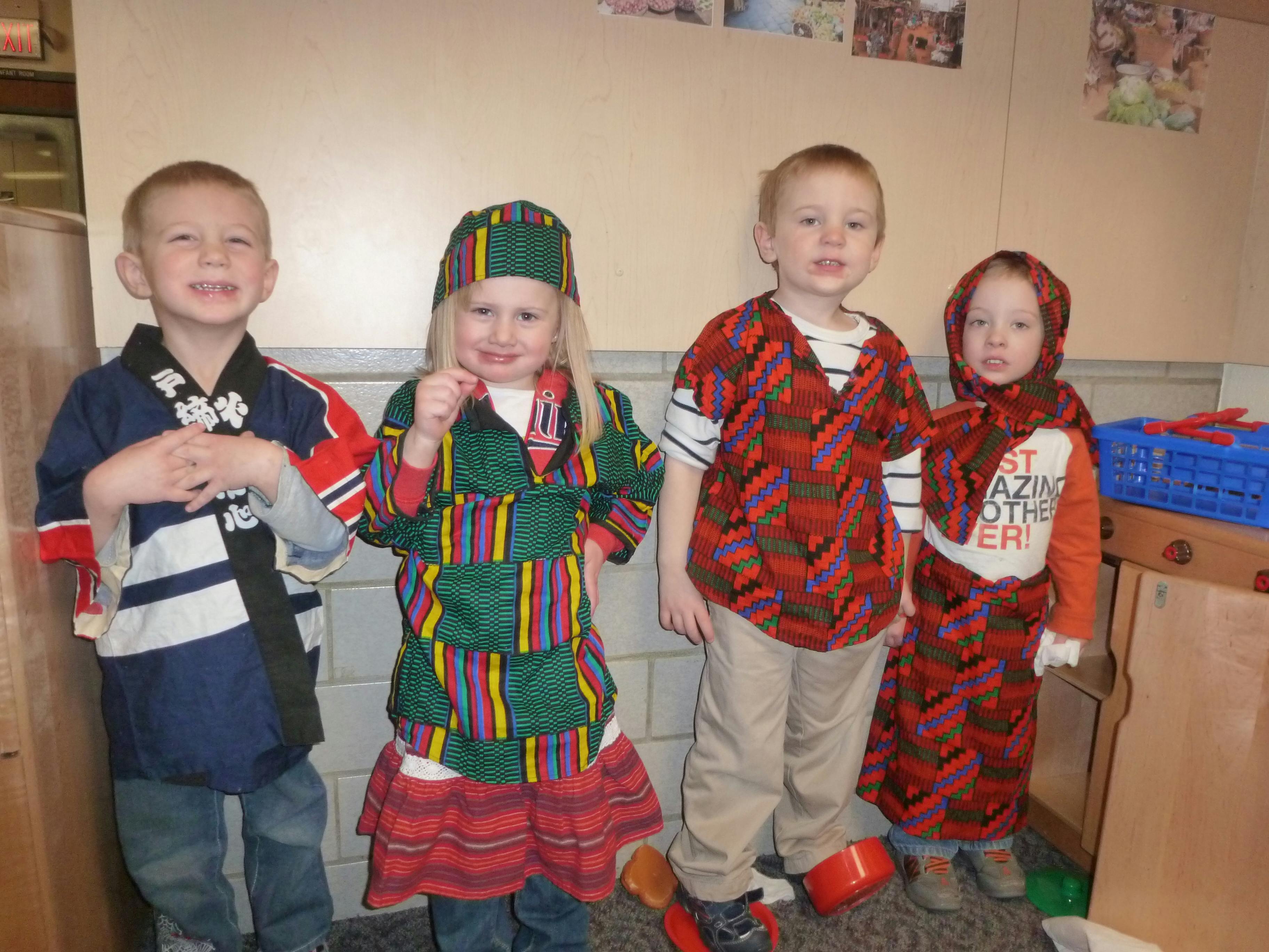 Four children in colorful costumes standing costumes