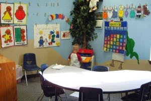 Child sitting at a table in a classroom