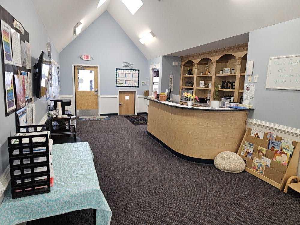 reception area with a counter, shelving, and a small bookshelf for children