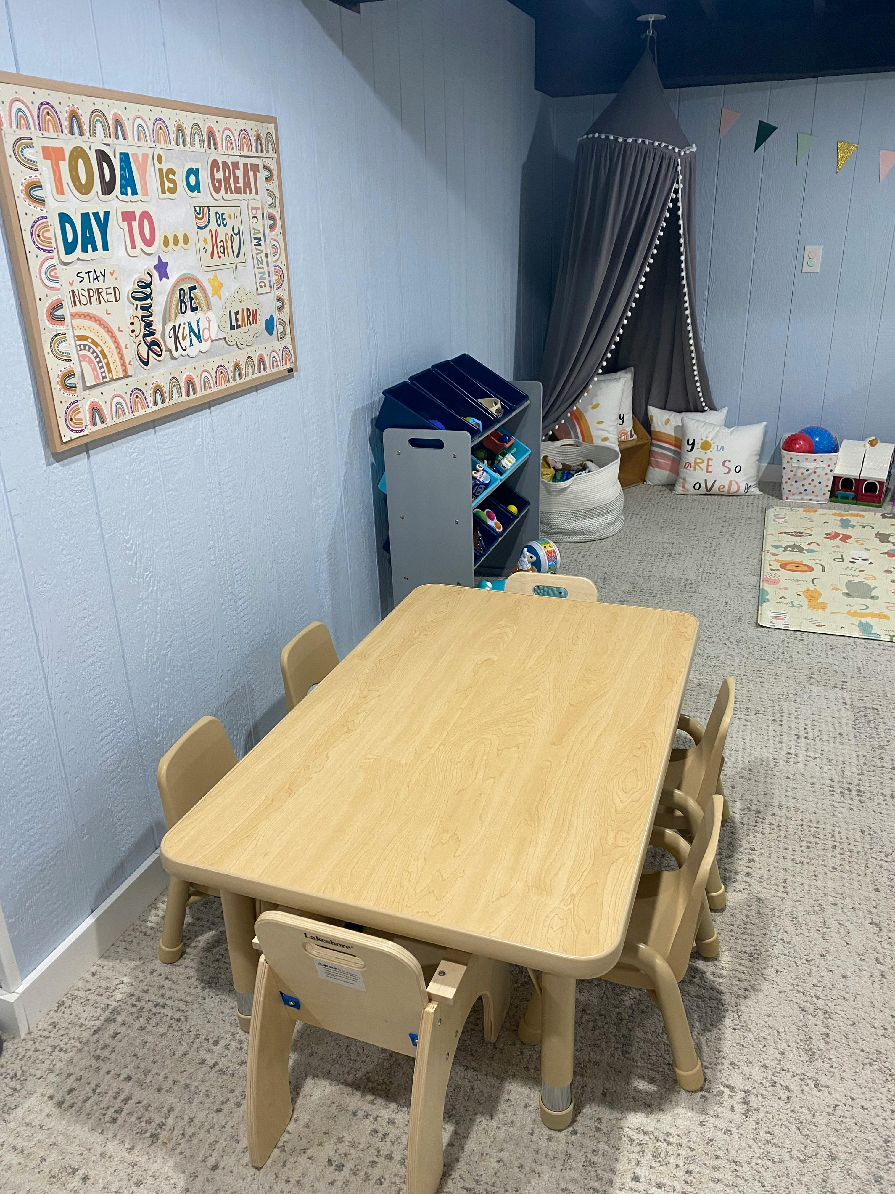 Children's table and chairs in a playroom with a sign that reads "TODAY is a GREAT DAY TO..."