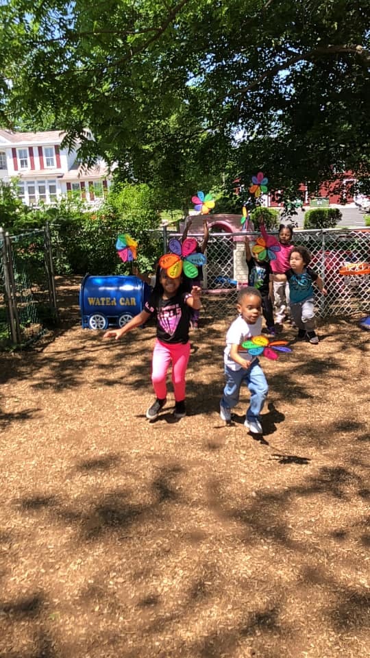 Children playing outdoors with pinwheels