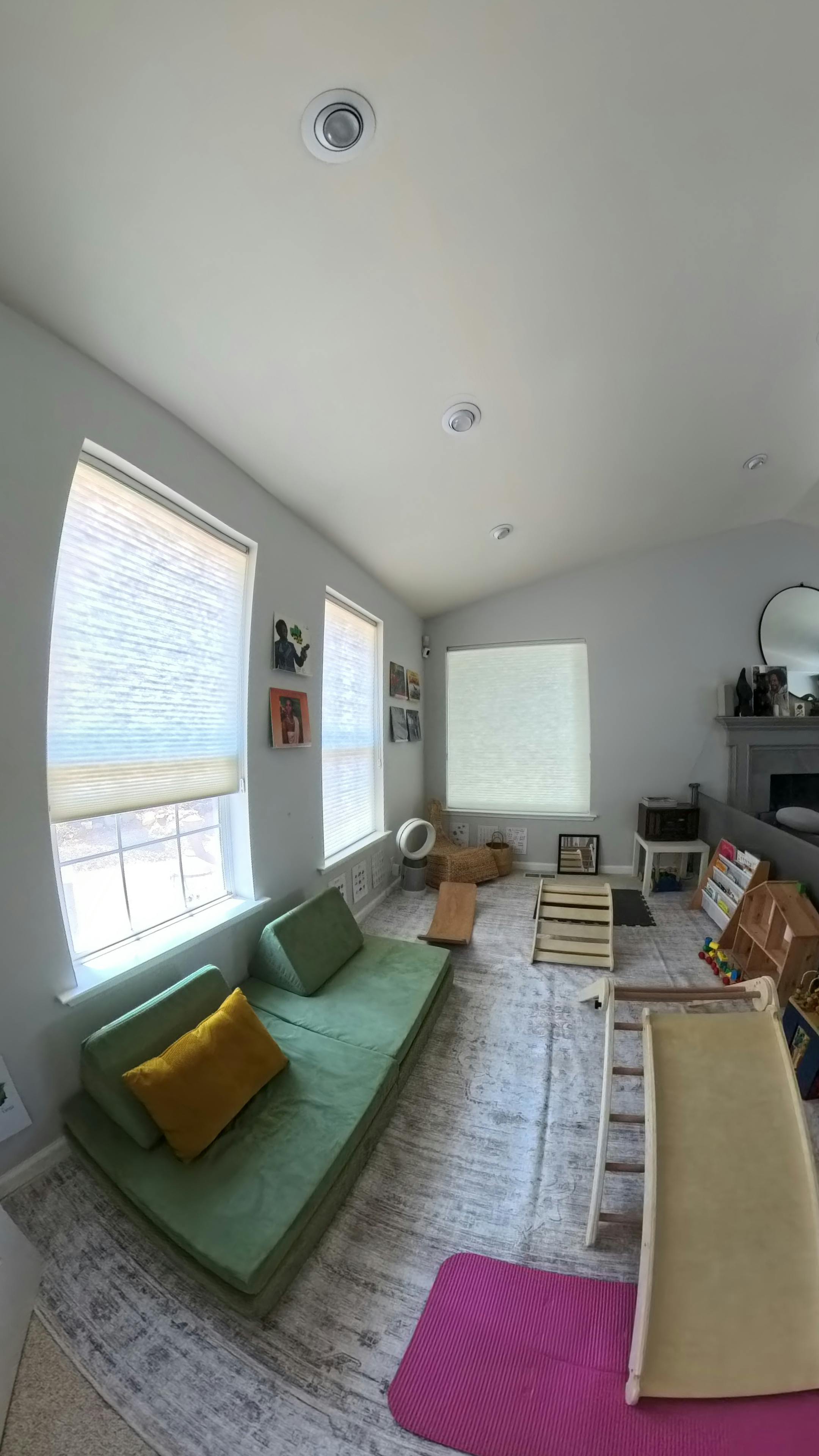 Playroom with green modular sofa, slide, and climbing structures