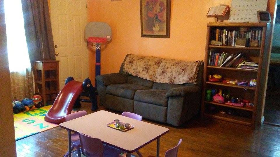 Living room with a sofa, bookshelf, and children's play area
