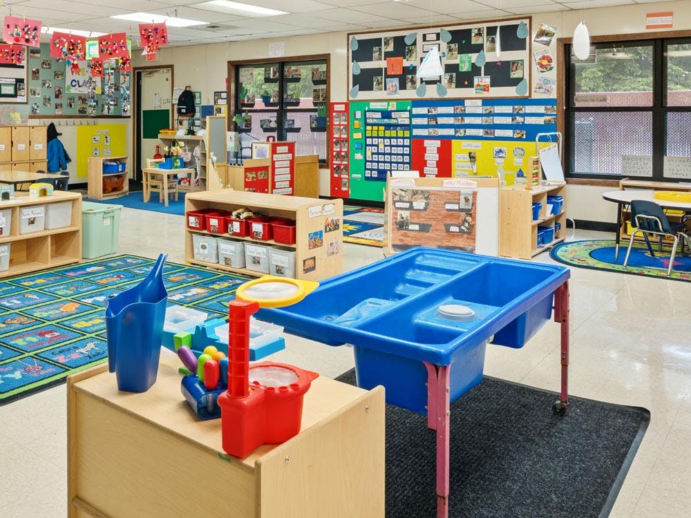 Empty colorful preschool classroom with a water play table in the foreground