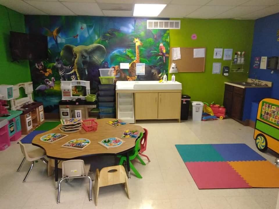 Classroom with a mural of jungle animals, child-sized table and chairs
