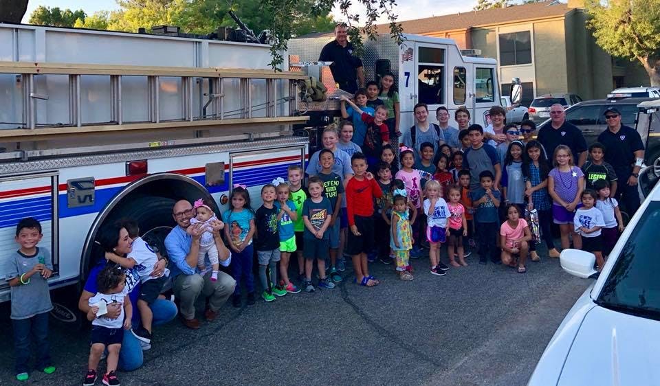 Group of people and children posing in front of a fire truck