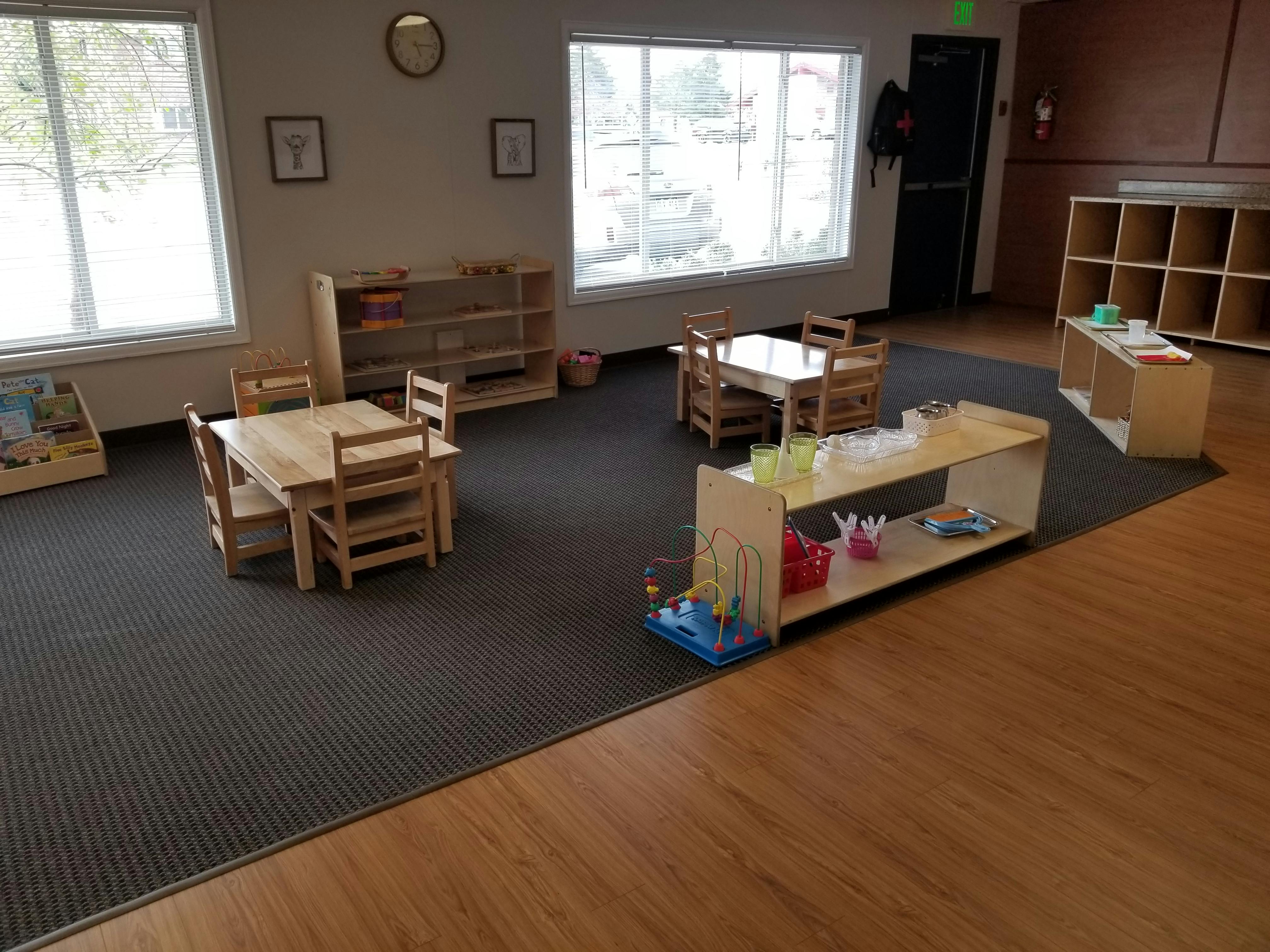 Empty classroom with small wooden tables and chairs