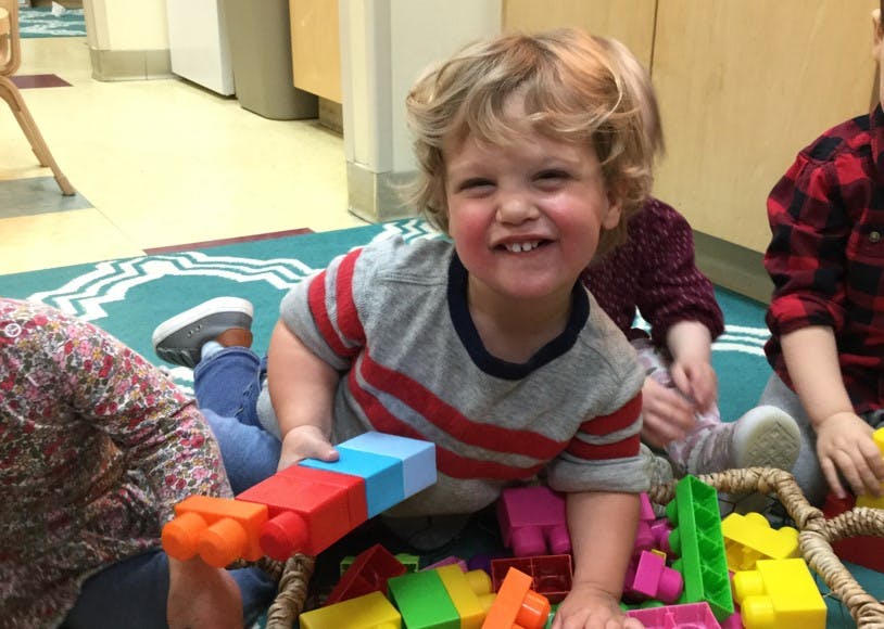 Child playing with colorful building blocks