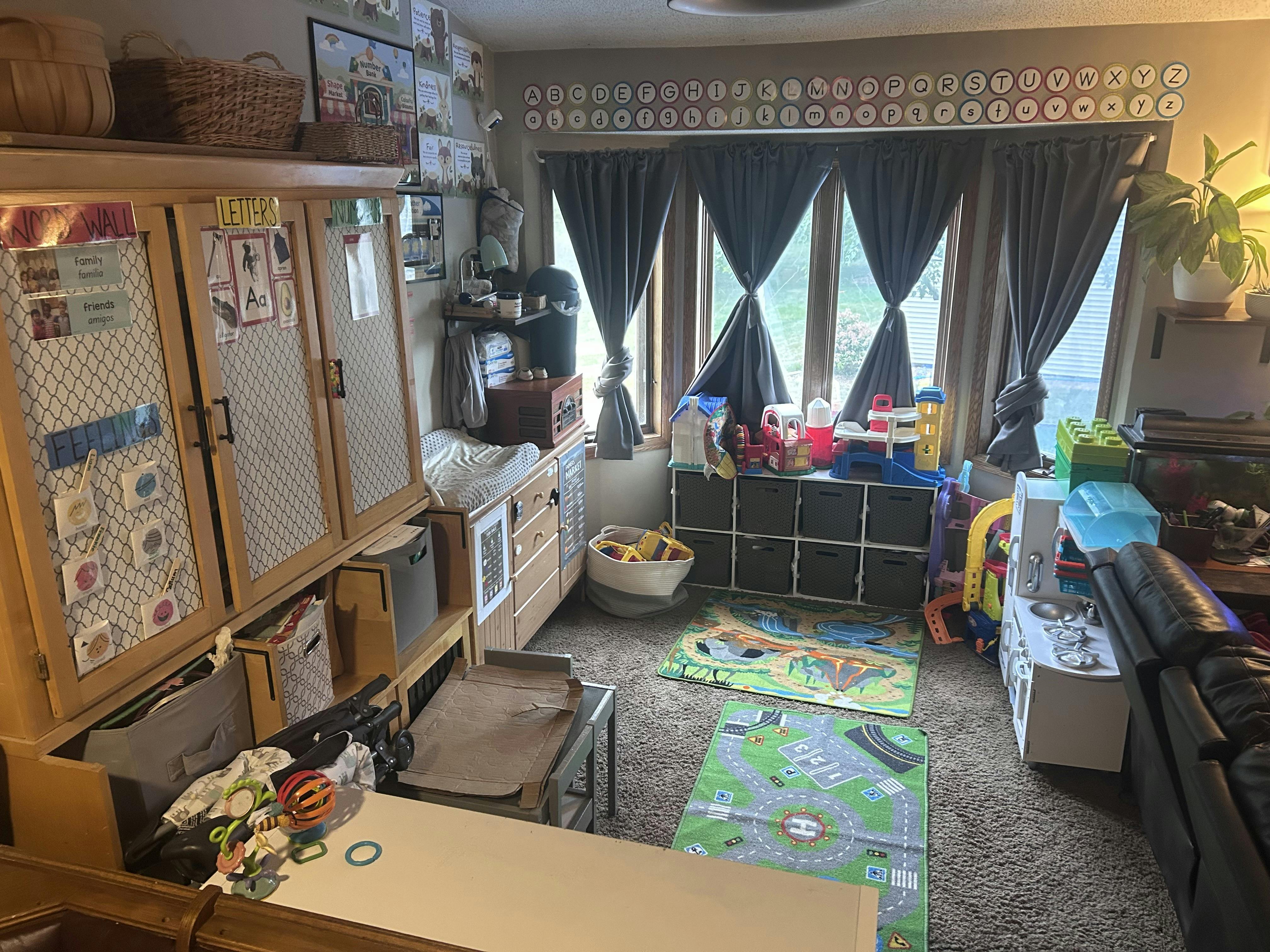Playroom with educational wall charts and various toy storage bins