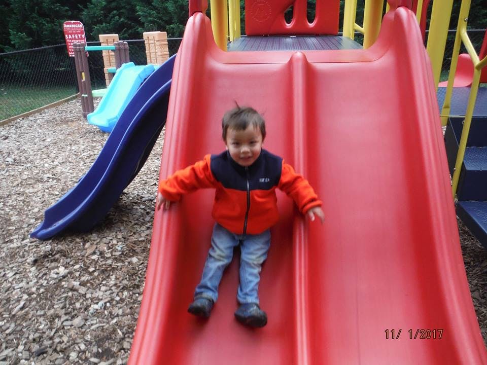 Child on a red playground slide