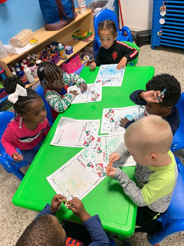 Children coloring at a green table