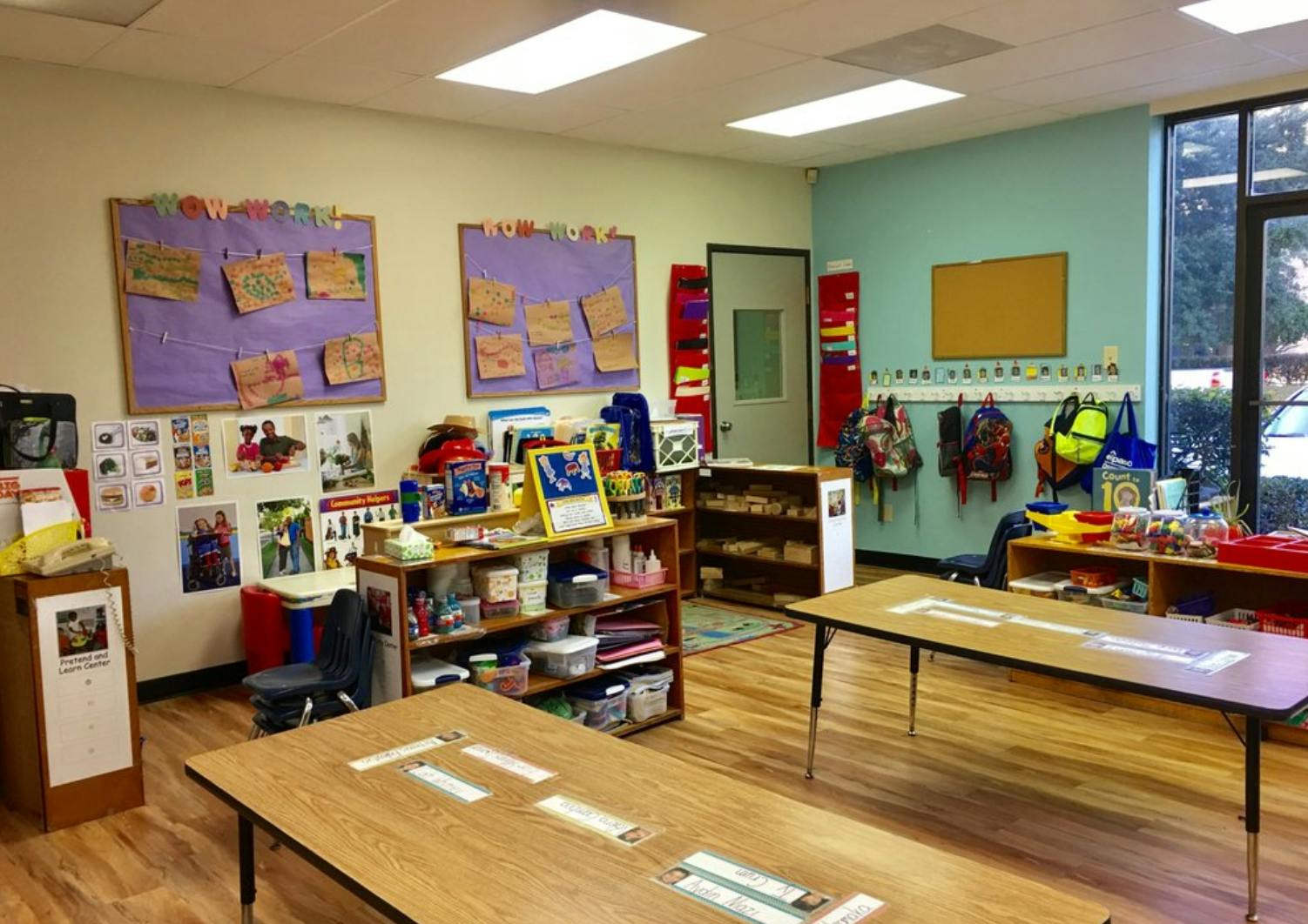 Classroom with tables, shelves, and bulletin boards