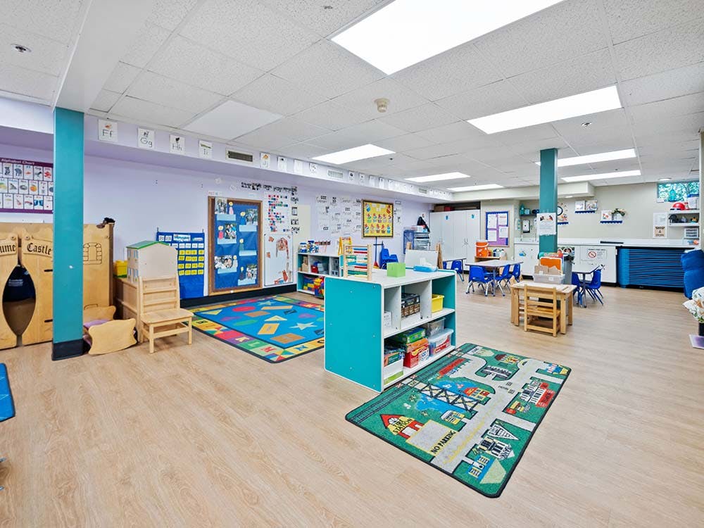 Empty classroom with children's furniture, rugs, and decorations