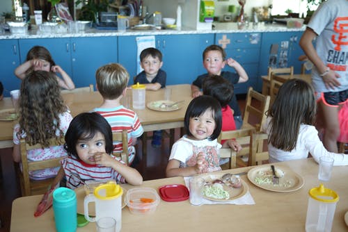Children sitting at tables in a classroom